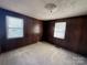 Bedroom offering natural light from two windows, wood paneling, and neutral carpeting at 3412 1St Avenue Nw Cir, Hickory, NC 28601