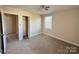 Bright bedroom featuring two windows, neutral walls, carpet, ceiling fan, and closet access at 3412 1St Avenue Nw Cir, Hickory, NC 28601