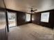 Spacious living room with wood paneling, a ceiling fan, carpeted floors, and natural light at 3412 1St Avenue Nw Cir, Hickory, NC 28601