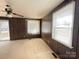 Bright living room with wood paneled walls and two windows with blinds at 3412 1St Avenue Nw Cir, Hickory, NC 28601