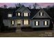 Elegant home at dusk featuring a welcoming front porch and dark shutters against a light facade at 411 Belo Ct, Fort Mill, SC 29715