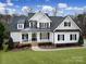 Beautiful two-story home boasts a manicured lawn and a welcoming front porch with classic black shutters and white trim at 411 Belo Ct, Fort Mill, SC 29715