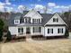 Beautiful two-story home featuring a black metal roof, white siding, and manicured landscaping at 411 Belo Ct, Fort Mill, SC 29715