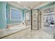 Bright bathroom with a glass enclosed shower, soaking tub, and decorative window at 411 Belo Ct, Fort Mill, SC 29715