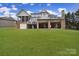 Back of home featuring an elevated deck, a screened porch, and a brick facade, set against a sprawling green lawn at 411 Belo Ct, Fort Mill, SC 29715