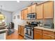 Bright kitchen featuring stainless steel appliances, wood cabinets, granite countertops, and hardwood floors at 4462 Haddington Dr, Fort Mill, SC 29707
