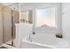 Main bathroom highlighting the soaking tub and tiled shower with a glass door and a privacy window at 4462 Haddington Dr, Fort Mill, SC 29707
