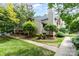 Exterior view of a condo showcasing mature trees and landscaping surrounding the property at 5011 Sharon Rd # B, Charlotte, NC 28210