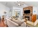 Open concept living room with a brick fireplace, hardwood floors, and access to outdoor patio at 5011 Sharon Rd # B, Charlotte, NC 28210