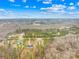 An aerial view showcases the neighborhood houses surrounded by a natural, wooded landscape with clear blue skies at 5147 Star Magnolia Ct, Clover, SC 29710