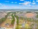 An aerial view showcases the neighborhood houses and homesites surrounded by a natural, wooded landscape with clear blue skies at 5147 Star Magnolia Ct, Clover, SC 29710