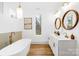 A sleek bathroom with a double sink vanity, free standing tub and wood look flooring at 5147 Star Magnolia Ct, Clover, SC 29710