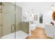 A glass enclosed shower and free standing tub in a modern bathroom with light colored tile and wood look floors at 5147 Star Magnolia Ct, Clover, SC 29710
