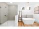 A free standing tub and glass enclosed shower with light colored walls and wood look flooring create a spa-like bathroom at 5147 Star Magnolia Ct, Clover, SC 29710