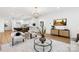 Open living space with modern decor, light-colored wood floors, and a kitchen view at 5147 Star Magnolia Ct, Clover, SC 29710