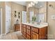 Well-lit bathroom with double sinks, wooden vanity, and decorative fixtures at 5472 Ives Nw St, Concord, NC 28027