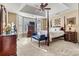 Bright bedroom features a tray ceiling, four poster bed, and comfortable seating at 5472 Ives Nw St, Concord, NC 28027