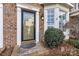 Inviting front door of a brick home with decorative door surround, transom, and meticulously maintained landscaping at 5472 Ives Nw St, Concord, NC 28027