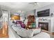 Cozy open-concept living room with hardwood floors, a fireplace, and an adjacent kitchen area at 5472 Ives Nw St, Concord, NC 28027