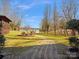 Scenic backyard with a stone walkway leading to the lake, surrounded by mature trees and landscaping at 5981 Johnson Rd, Lake Wylie, SC 29710