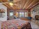 Bedroom boasting exposed wooden beams, natural light, and a rustic stone fireplace at 5981 Johnson Rd, Lake Wylie, SC 29710