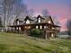 Stunning log home with a wraparound porch, nestled on a lush green lawn near the water's edge at 5981 Johnson Rd, Lake Wylie, SC 29710