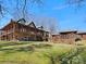 Spacious log home featuring stone accents, multiple balconies, and lush lawn with mature landscaping at 5981 Johnson Rd, Lake Wylie, SC 29710