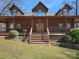 Charming log home featuring a welcoming front porch with wooden railings and a beautifully landscaped yard at 5981 Johnson Rd, Lake Wylie, SC 29710