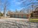 Log-style detached garage featuring multiple bays and green doors, set on a gravel driveway at 5981 Johnson Rd, Lake Wylie, SC 29710