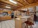 Open kitchen with wood cabinetry, bar seating, and a view of the living area and stone fireplace at 5981 Johnson Rd, Lake Wylie, SC 29710