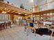 Open-concept living and dining area with wood beam construction, tile floors, and kitchen with bar seating at 5981 Johnson Rd, Lake Wylie, SC 29710