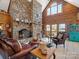 Inviting living room with a stone fireplace, comfortable seating, and large windows, perfect for relaxation and gatherings at 5981 Johnson Rd, Lake Wylie, SC 29710