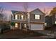 Charming two-story home with stone accents, a manicured lawn, and a two-car garage at 6131 Blue Ash Ln, Charlotte, NC 28215