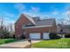 The exterior of a beautiful brick home with a well-manicured lawn and three-car garage at 714 Castlestone Ln, Matthews, NC 28104