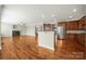 Open-concept living space featuring hardwood floors, a fireplace, a kitchen and stainless steel appliances at 714 Castlestone Ln, Matthews, NC 28104