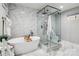 Elegant bathroom featuring a soaking tub, glass shower, and marble tile at 8104 Stem Ct, Charlotte, NC 28227