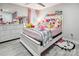 Bedroom featuring gray wood-look floors, white furniture, and many stuffed animals at 8104 Stem Ct, Charlotte, NC 28227