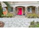 Inviting front entrance with a vibrant red door, stone pillars, manicured landscaping, and a decorative walkway at 8104 Stem Ct, Charlotte, NC 28227