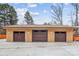 Large three-car detached garage featuring modern doors and exterior lighting at 8104 Stem Ct, Charlotte, NC 28227