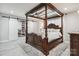 Spacious main bedroom with a four-poster bed, ample closet space, modern decor, and natural light at 8104 Stem Ct, Charlotte, NC 28227