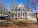 Charming two-story home featuring a welcoming front porch, complemented by mature landscaping and a well-maintained lawn at 8251 Kale Pl, Harrisburg, NC 28075