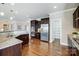 Spacious kitchen with stainless steel appliances, granite counters, dark wood cabinets, and pantry at 8501 Caesars Head Dr, Waxhaw, NC 28173