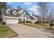 A classic house is framed by a long driveway and neighboring homes, showcasing suburban living at 910 Elrond Nw Dr, Charlotte, NC 28269