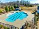 Community pool surrounded by a black metal fence and concrete pool deck and neighborhood at 1024 Mayapple Way, Belmont, NC 28012