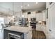 Modern kitchen features white cabinets, stainless steel appliances, a granite island, and pendant lighting at 1024 Mayapple Way, Belmont, NC 28012