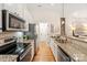 Galley kitchen with granite counters, stainless appliances, and tile backsplash at 1055 Curry Way, Matthews, NC 28104