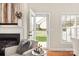 Bright living room featuring a fireplace and glass door with view to the backyard and white picket fence at 1055 Curry Way, Matthews, NC 28104