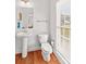 Cozy bathroom featuring a pedestal sink, toilet, and bright window at 109 Putney Ct, Salisbury, NC 28147