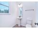 Bathroom featuring a stand-up sink, toilet, mirror, and large window allowing natural light at 111 Megby Trl, Statesville, NC 28677