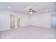 Spacious bedroom with neutral carpet, ceiling fan, and views into the bathroom and walk-in closet at 111 Megby Trl, Statesville, NC 28677